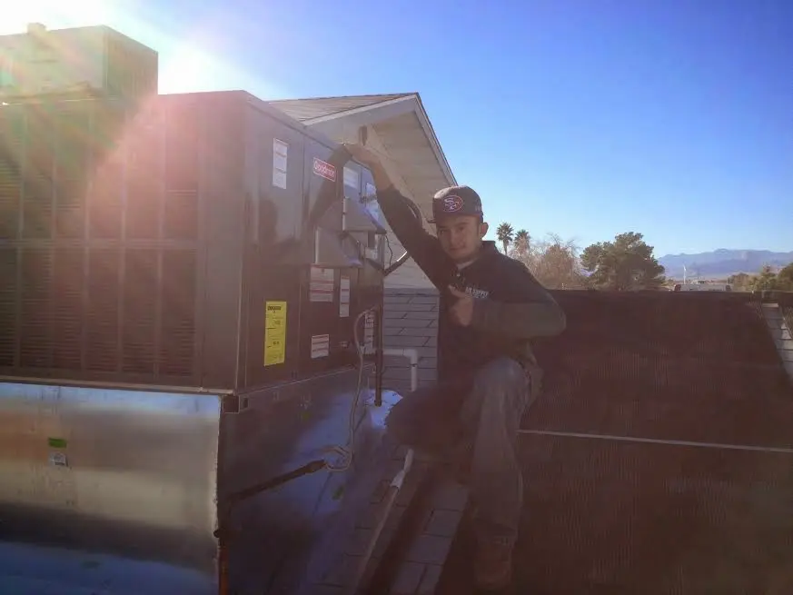 HVAC technician performing Boiler Repair on a rooftop unit in Dunbar